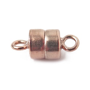 Può includere: Una chiusura magnetica in oro rosa per la creazione di gioielli. La chiusura è cilindrica con due estremità ad anello per il fissaggio a una collana o un braccialetto. Le due metà della chiusura sono tenute insieme da un magnete.