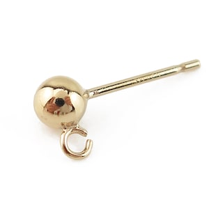 May include: A gold-toned earring with a small ball at the end and a loop on the side. The earring post is straight and has a small, flat end.