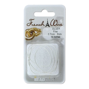 May include: A package of silver French wire, 0.7mm thick and 14 inches long. The package is labeled "French Wire" with a small Eiffel Tower graphic and "SILVER Fine 0.7mm thick 14 inches". The package is from the Beadsmith brand.