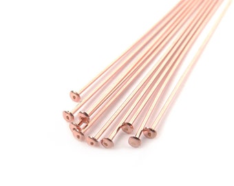 Può includere: Un mazzo di spilli per la testa piatta in oro rosa. Gli spilli sono disposti a ventaglio.
