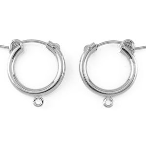 May include: A pair of silver hoop earrings with a small loop hanging from the bottom of each hoop.