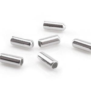 Peut inclure: Six petits cylindres métalliques argentés, des perles à sertir. Chaque perle a une extrémité arrondie et un trou à l'autre extrémité. Ces composants sont utilisés en bijouterie et artisanat. Chaque perle mesure environ 1 cm de long.
