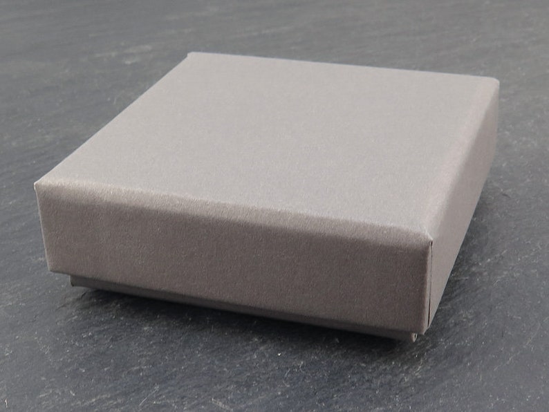 K&ouml;nnte beinhalten: Eine graue, rechteckige Box mit einer glatten, strukturierten Oberfl&auml;che.