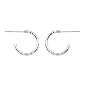 May include: A pair of small, silver hoop earrings. Each earring has a curved, semi-circular design with a straight post for insertion into the ear. The earrings are shown against a white background.