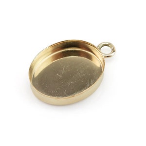 Puede incluir: Un engaste de colgante ovalado de oro con un bucle para sujetar una cadena. El engaste está diseñado para sujetar una piedra cabujón.