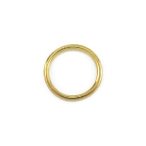 May include: A gold-coloured metal ring with a smooth, rounded surface.