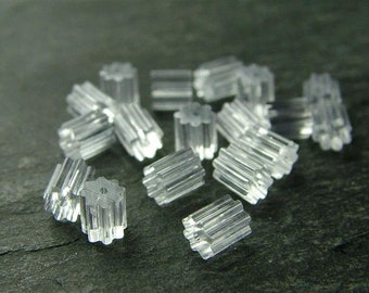May include: A pile of clear plastic earring backs. The backs have a star-shaped design and are designed to hold earrings in place.