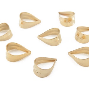 May include: Eight gold teardrop-shaped pendant bails, each with a small hole at the top for attaching a pendant.