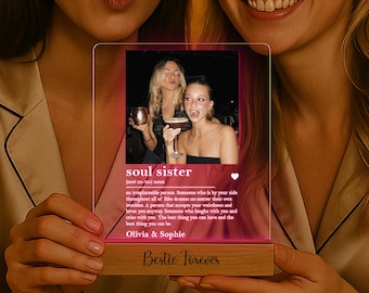 May include: A clear acrylic photo frame with a wooden base, featuring a photo of two women and the text "soul sister." The frame is illuminated with a pink glow, and the base reads "Bestie Forever."