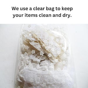 May include: A clear plastic bag with a white floral pattern containing various white and off-white lace trims. The text on the image reads: We use a clear bag to keep your items clean and dry. The lace pieces feature different textures and patterns.