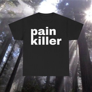 以下が含まれることがあります： 白文字で「pain killer」と書いてある黒いTシャツ。フォントは太字です。