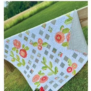 May include: A quilt pattern called "Rose Trellis" by Sally Lawrence Designs. The quilt is made with a white background and features a trellis design with pink and green flowers. The quilt is 75 1/2 inches by 70 1/2 inches and is fat quarter friendly.