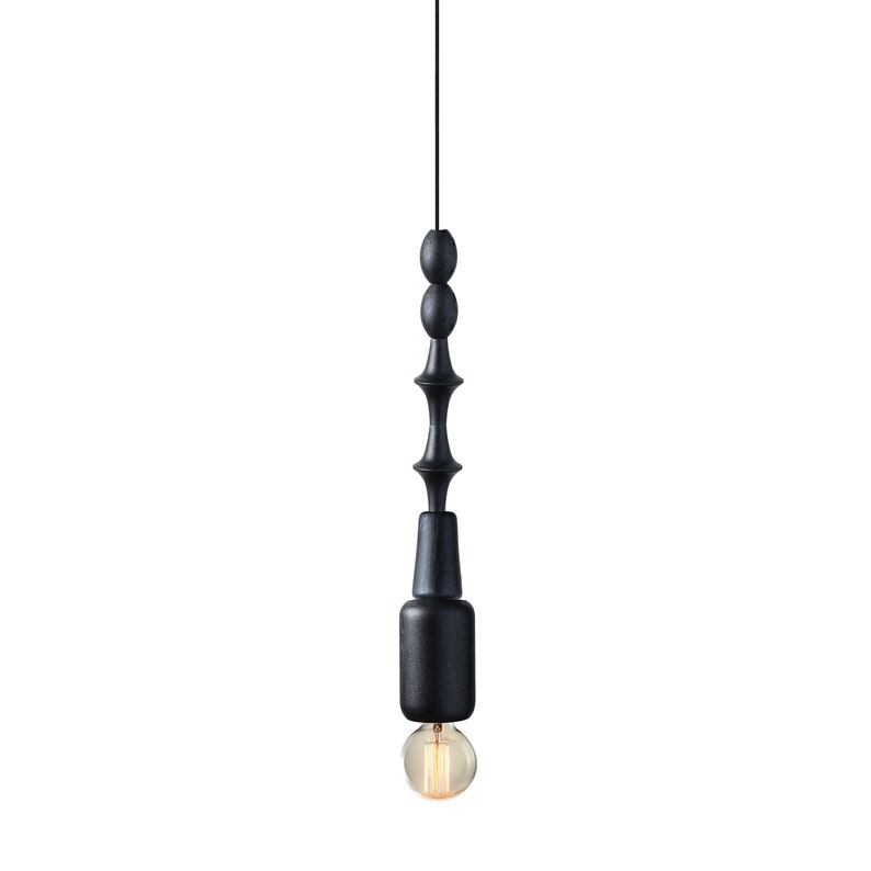 Black wooden pendant light with geometric sculptural design and Edison bulb, creating a bold, industrial statement in modern interiors