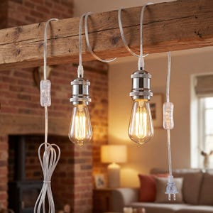 Puede incluir: Dos bombillas de estilo Edison cuelgan de una viga de madera. Las bombillas tienen un brillo cálido y amarillo y están suspendidas por cables transparentes. Los accesorios tienen un acabado plateado, y los cables conducen a un interruptor y un enchufe.