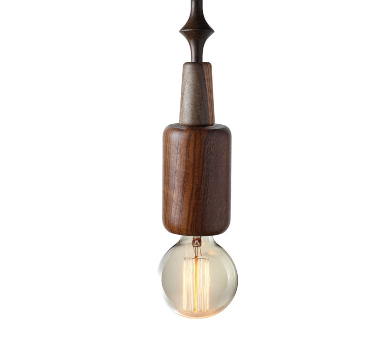 Dark wood pendant light featuring unique sculptural lines and Edison bulb, adding a touch of rustic sophistication to urban loft spaces