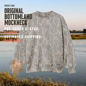 Może przedstawiać: Bluza z długim rękawem i stójką w szaro-beżowy wzór moro. Tekst na obrazku brzmi: MOSSY OAK ORIGINAL BOTTOMLAND MOCKNECK. PRE-ORDER STATUS: CLOSED. ESTIMATED SHIPPING: NOVEMBER. Na dole znajduje się mała czarna metka z logo marki.