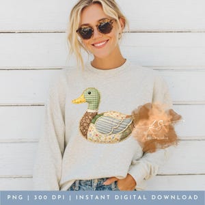 Pode incluir: Camisola cinza claro com um design de pato em patchwork. O pato tem uma cabe&ccedil;a verde xadrez, corpo castanho e asas florais e listradas. O texto na parte inferior diz "PNG | 300 DPI | INSTANT DIGITAL DOWNLOAD".