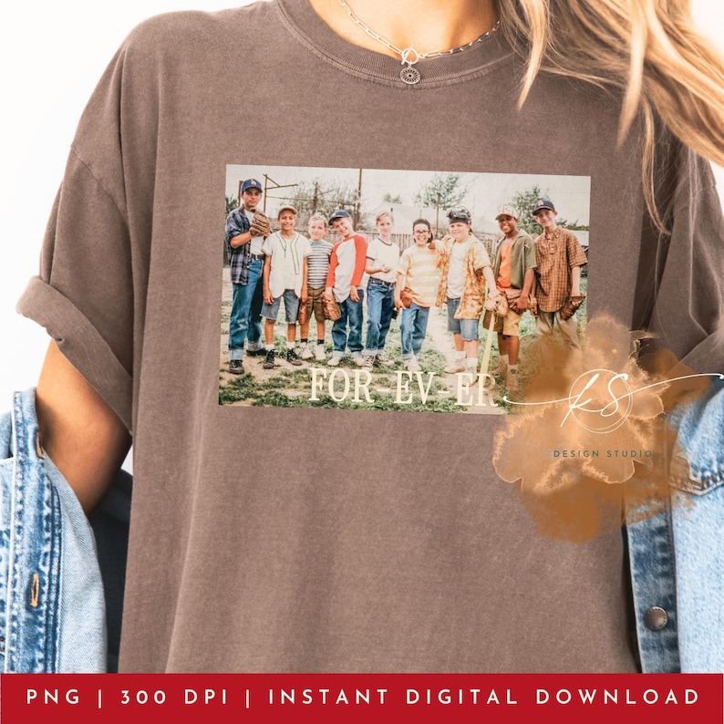 May include: A brown t-shirt featuring a graphic of a group of boys in baseball attire with the text "FOR EVER". The shirt has rolled-up sleeves and a vintage aesthetic. The design includes the text "KS DESIGN STUDIO".