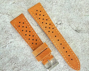 Könnte beinhalten: Zwei braune Lederarmbänder mit perforiertem Design. Die Armbänder haben ein hellbraunes Nähdetail.