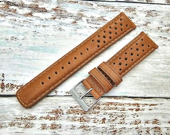 Könnte beinhalten: Ein braunes Lederarmband mit perforiertem Design. Das Armband hat eine silberne Schließe.