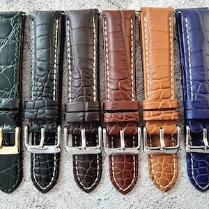 Puede incluir: Seis correas de reloj de cuero de diferentes colores con costuras blancas. Las correas son todas del mismo tamaño y tienen una hebilla plateada.