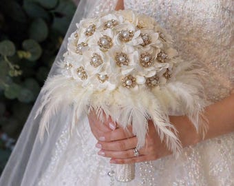 Elegante ramo de novia hecho a mano con detalles dorados y flores de boda color marfil.