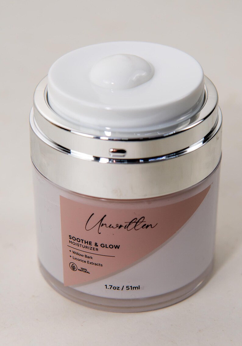 Puede incluir: Un tarro blanco con tapa plateada etiquetado como "Unwritten Soothe & Glow Moisturizer" con los ingredientes "Willow Bark, Licorice Extracts" y el texto "100% Natural" y "1.7oz / 51ml".