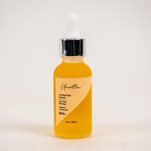 Puede incluir: Un frasco de vidrio de suero hidratante con un gotero. El frasco est&aacute; etiquetado con "Unwritten" y "Hydrating Serum". El suero es de color amarillo claro. El frasco es de 30 ml.