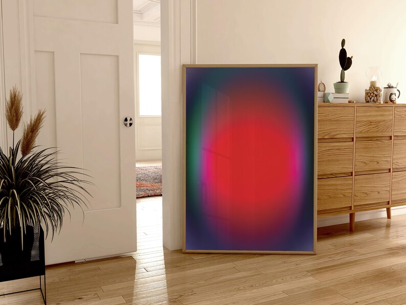 May include: A framed abstract art print with a gradient of colours, including green, purple, pink, and red. The print features a large, circular, red shape in the centre.
