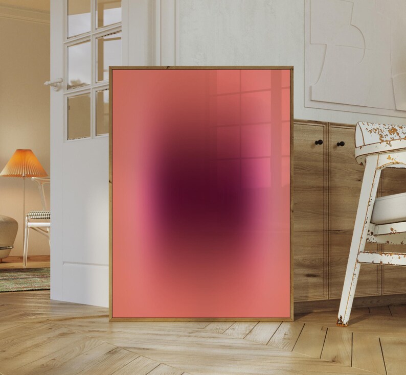 May include: A framed abstract art print with a pink to purple gradient. The print has a blurred effect, creating a soft, dreamy look.