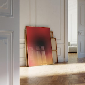Puede incluir: Una gran pintura abstracta con un degradado de colores rojo, naranja y amarillo. La pintura está enmarcada en un fino marco dorado y se apoya contra una pared blanca.