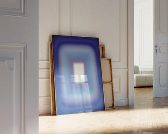 May include: A framed abstract painting with a blue, white, and light blue gradient. The painting is in a gold frame and is leaning against a white wall.