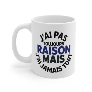 Peut inclure: Mug en céramique blanche avec une anse incurvée. Le mug présente le texte français "J'AI PAS TOUJOURS RAISON MAIS JAMAIS TORT" en lettres noires et bleues, qui se traduit par "Je n'ai pas toujours raison, mais jamais tort."