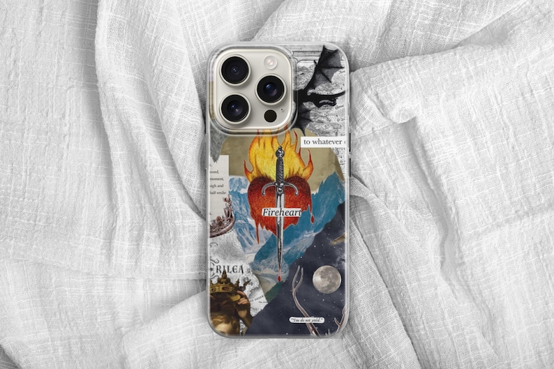 May include: A clear smartphone case featuring a collage design with a central red heart pierced by a silver sword surrounded by orange flames. The graphic includes a black dragon silhouette, a moon, a crown, and text reading Fireheart and Rilea.