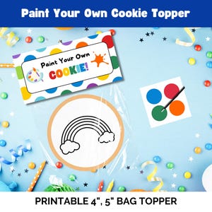 以下が含まれることがあります： 虹のクッキーのデザインと「あなただけのクッキーを塗ろう！」というテキストが書かれた、印刷可能な4インチと5インチのバッグトッパー。トッパーは、カラフルなコンフェッティとペイントブラシが付いたペイントパレットが置かれた青い背景の上にあります。
