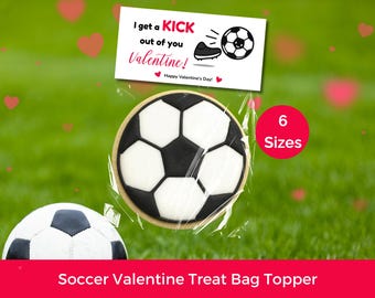 Pode incluir: Um biscoito em forma de bola de futebol em embalagem de celofane, com uma etiqueta de Dia dos Namorados que diz "I get a KICK out of you Valentine!" e "Happy Valentine's Day!". Um círculo vermelho indica "6 Sizes". A faixa inferior diz "Soccer Valentine Treat Bag Topper".