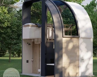 May include: A two-story modular structure with a dark gray frame and white curved roof. The interior features a lofted sleeping area, a lower level with a small kitchen or workspace, and a side entrance. The text "HOMECON STUDIO" is visible.