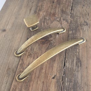 Conjunto de ferragens vintage em latão antigo para armários: puxadores de gaveta em arco e botão quadrado.
