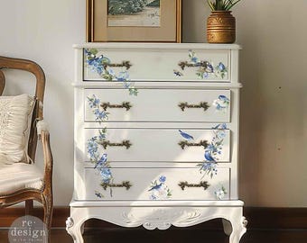 May include: A white four-drawer chest of drawers featuring decorative floral and blue bird transfers across the front. The piece has ornate metal drawer pulls and curved legs. The text #674601 garden whispers is visible in the bottom left corner.