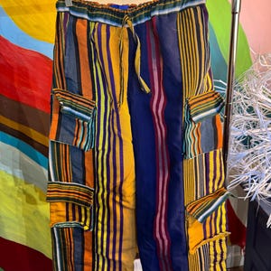 Close up of multicolored striped Asoke fabric on baggy cargo pants with pockets