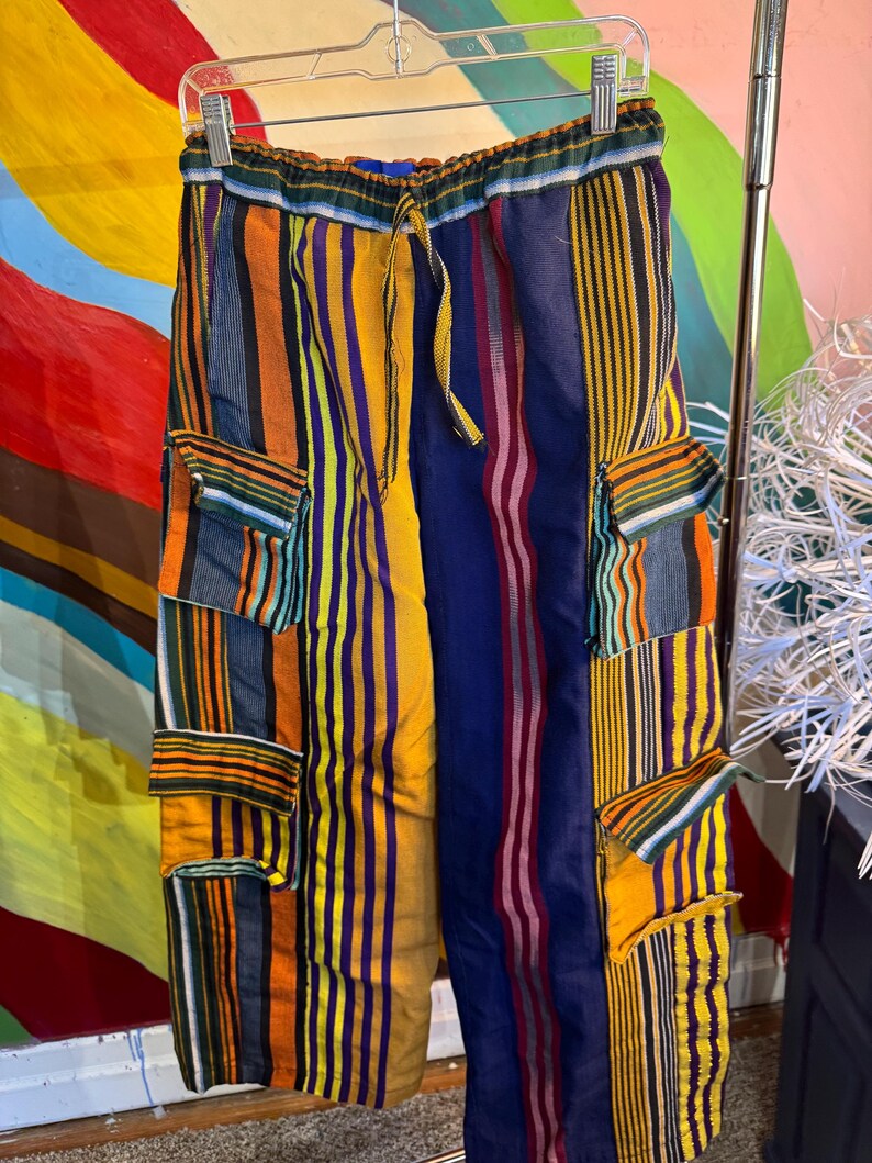 Close up of multicolored striped Asoke fabric on baggy cargo pants with pockets