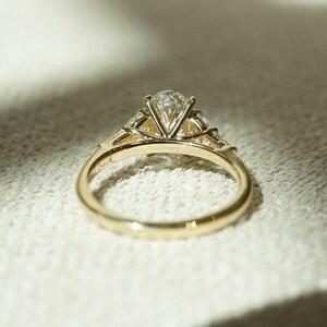 Timeless 2.05tcw oval lab grown diamond ring with three stones and a cathedral-style shank. A perfect anniversary or wedding gift for her, this elegant ring combines sustainable sparkle and romantic symbolism in a forever design.