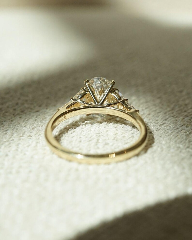 Timeless 2.05tcw oval lab grown diamond ring with three stones and a cathedral-style shank. A perfect anniversary or wedding gift for her, this elegant ring combines sustainable sparkle and romantic symbolism in a forever design.