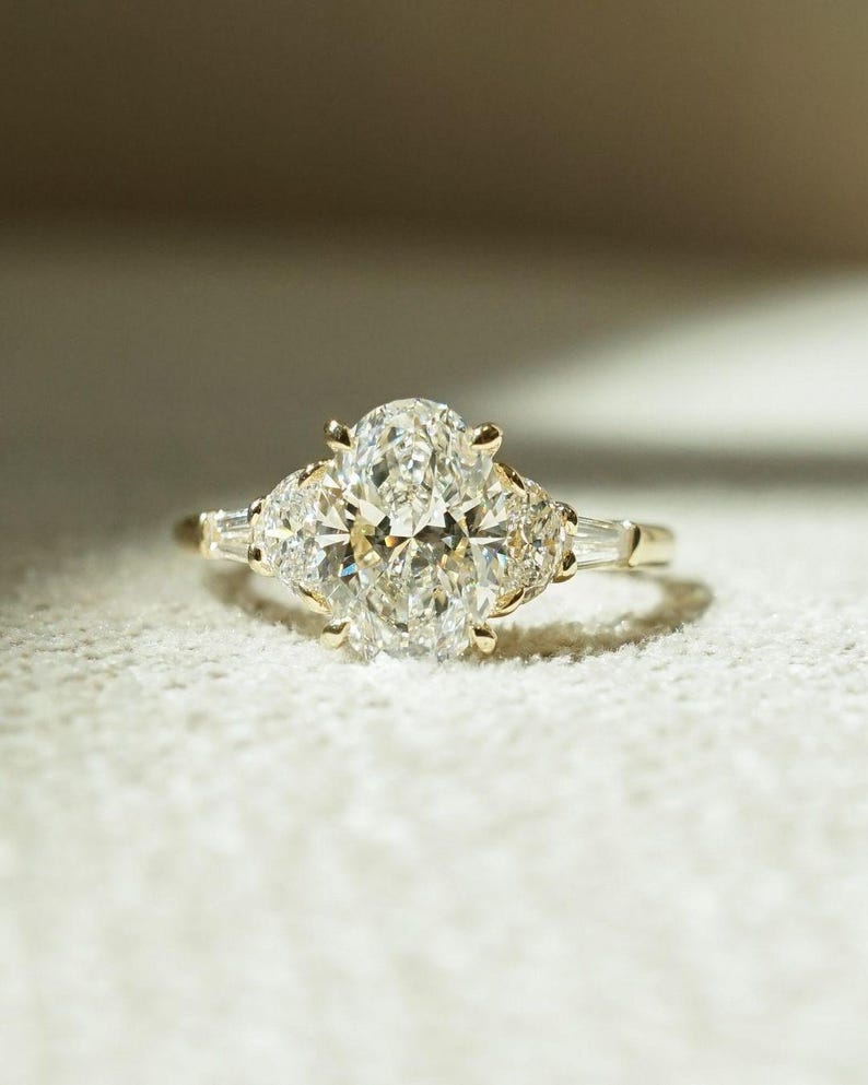Elegant 2.05tcw oval lab grown diamond three stone engagement ring with a cathedral shank design. A forever classic ring symbolizing past, present, and future—perfect as an anniversary gift, wedding ring, or timeless keepsake for her.