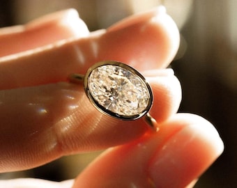 May include: A gold ring with a large, oval-shaped diamond.