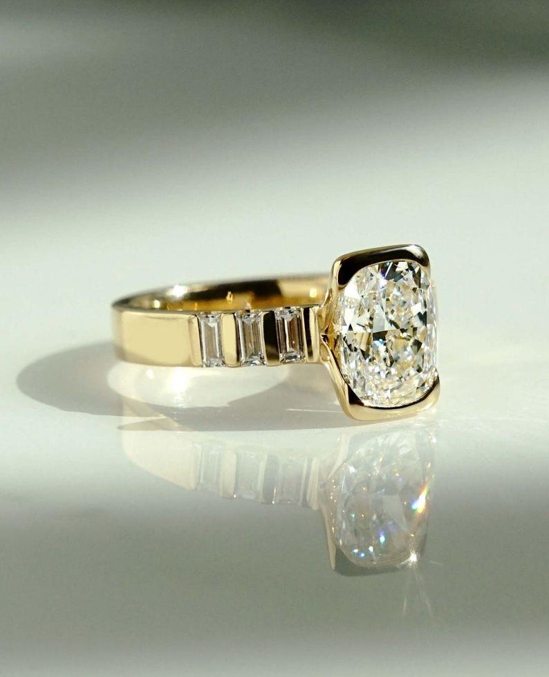 This 2ct lab-grown cushion diamond ring features a modern half bezel design and flowing flair shank band. A beautiful engagement or birthday gift ring for her, crafted with love and responsibility—ideal for anniversaries or as a heartfelt promise ring.