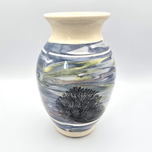 May include: A set of three ceramic mugs with a speckled, matte finish. The mugs are in shades of cream, light gray, and dark gray. Each mug has a simple, minimalist design, perfect for coffee or tea.