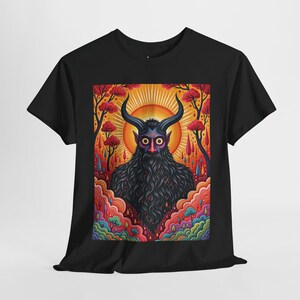 May include: Black t-shirt featuring a colourful graphic print of a horned, bearded creature with glowing eyes. The creature is surrounded by a psychedelic landscape of trees and clouds.