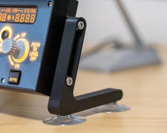 May include: A black aircraft instrument panel with a digital display showing "88888 +8.888", a knob with "UP" and "DN" labels, and a button labelled "APPR". The panel is mounted on a black metal stand with suction cups.