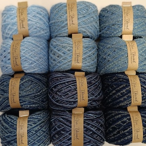 K&ouml;nnte beinhalten: Zw&ouml;lf Kn&auml;uel Garn in verschiedenen Blaut&ouml;nen, jedes Kn&auml;uel mit dem Etikett "Vin-Thread Artisan Vintage Threads".